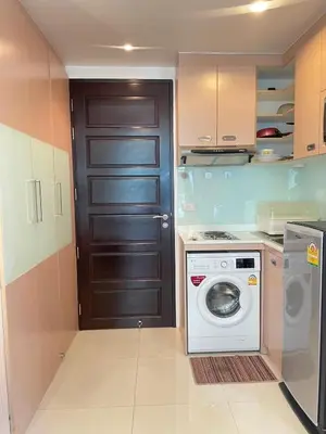 a kitchen with a washing machine and a door at Sabai Stay in Patong Beach