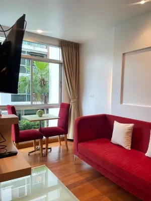 a living room with a red couch and a table at Sabai Stay in Patong Beach