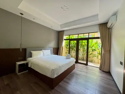 a bedroom with a bed and a large window at Ocean home in Laguna Phuket