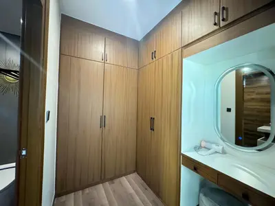 a bathroom with wooden cabinets and a sink and a mirror at Ocean home in Laguna Phuket