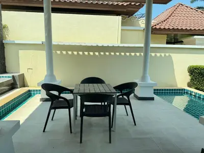 a table and chairs on a patio with a pool at Ocean home in Laguna Phuket