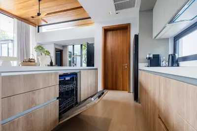 a kitchen with wooden cabinets and a wooden door at Botanica Foresta B10 in Ban Nong Chaeng