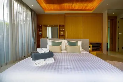 a bedroom with a large bed with towels on it at Luxpride Villa by Wallaya Villas in Ban Thalat Choeng Thale