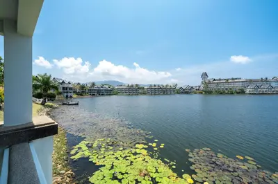 a view of a lake with buildings in the background at The Lake Front Laguna Alla13 in Laguna Phuket