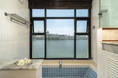 a bathroom with a window and a tub with a view of the water at The Lake Front Laguna Alla13 in Laguna Phuket