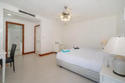 a bedroom with a bed and a desk and a ceiling fan at The Lake Front Laguna Alla13 in Laguna Phuket