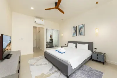 a bedroom with a bed and a flat screen tv at Villa Aura 3BR Private Pool Near Naiharn Beach by TropicLook in Rawai Beach