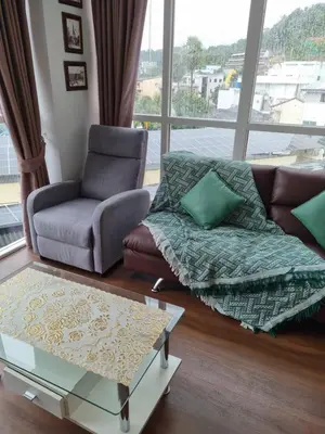 a living room with a couch and a glass table at Ozone Condotel Kata Beach by Pitjira in Phuket Town