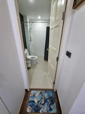 a bathroom with a toilet and a rug on the floor at Ozone Condotel Kata Beach by Pitjira in Phuket Town