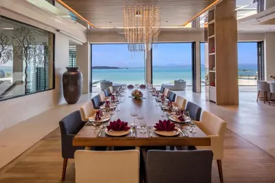 a long dining room with a long table and chairs at Villa Amaravida in Ko Lek
