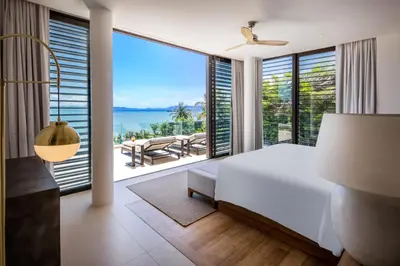 a bedroom with a bed and a view of the ocean at Villa Amaravida in Ko Lek