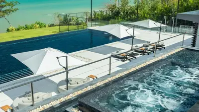 an image of a swimming pool with chairs and umbrellas at Villa Amaravida in Ko Lek