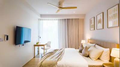 a bedroom with a bed and a desk and a window at BeachSide and SeaSide Residences Apartment 200 m to Bang Tao Beach in Bang Tao Beach