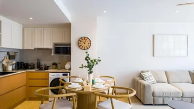 a kitchen and a living room with a table and chairs at BeachSide and SeaSide Residences Apartment 200 m to Bang Tao Beach in Bang Tao Beach
