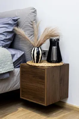 a night stand with a vase with feathers in it next to a bed at Suite Azure 1BR Laguna Beachside Bang Tao Beach in Bang Tao Beach