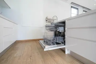 a kitchen with white walls and wooden floors and a dishwasher at 5 minutes from Laguna - Private Pool 3BR in Laguna Phuket