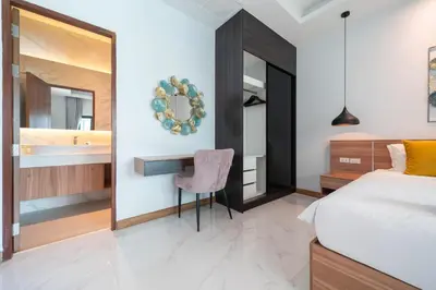 a bedroom with a bed and a desk and a mirror at 5 minutes from Laguna - Private Pool 3BR in Laguna Phuket