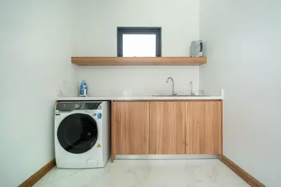 a kitchen with a washing machine and a sink at 5 minutes from Laguna - Private Pool 3BR in Laguna Phuket