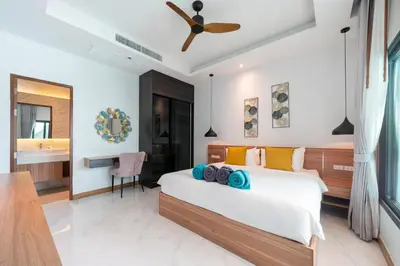 a bedroom with a bed with a ceiling fan at 5 minutes from Laguna - Private Pool 3BR in Laguna Phuket