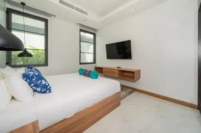 a bedroom with a bed and a tv on a wall at 5 minutes from Laguna - Private Pool 3BR in Laguna Phuket