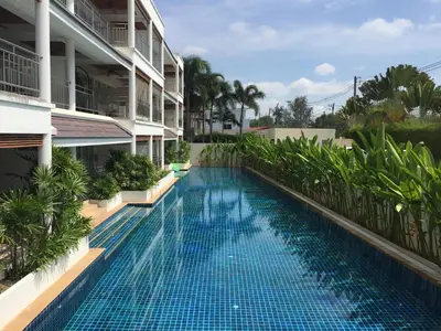 a swimming pool in front of a building at Bel Air Panwa Big Apartment in south Phuket near Ao Yon Beach, 3rd floor in Ban Ao Makham