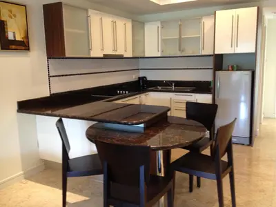 a kitchen with a table and chairs and a refrigerator at Bel Air Panwa Big Apartment in south Phuket near Ao Yon Beach, 3rd floor in Ban Ao Makham