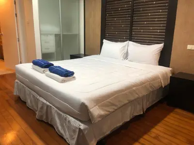 a large bed with two towels on top of it at Bel Air Panwa Big Apartment in south Phuket near Ao Yon Beach, 3rd floor in Ban Ao Makham