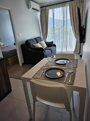 a living room with a table with two plates on it at IKON STAY Zcape 2 Condominium S in Bang Tao Beach
