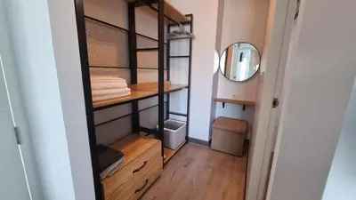a small closet with wooden shelves and a mirror at IKON STAY Zcape 2 Condominium S in Bang Tao Beach