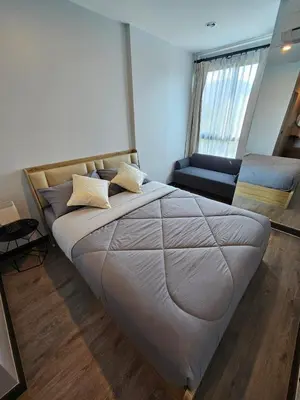 a large bed in a room with a couch at IKON STAY Zcape 2 Condominium S in Bang Tao Beach