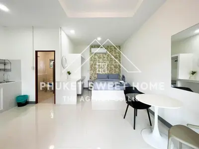 a white living room with a table and a bed at Naiharn Green Valley number 15 16 in Rawai Beach