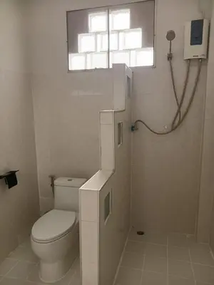 a bathroom with a toilet and a shower with a window at Sila Apartment in Ban Thalat Choeng Thale