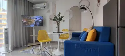 a living room with blue chairs and a table at Pool View Tropic Studio in Ban Mai Salae