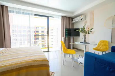 a hotel room with a bed and a table and chairs at Pool View Tropic Studio in Ban Mai Salae