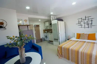 a bedroom with a bed and a blue couch at Pool View Tropic Studio in Ban Mai Salae