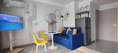 a living room with a blue couch and yellow chairs at Pool View Tropic Studio in Ban Mai Salae