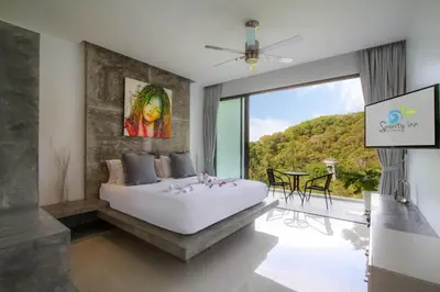 a bedroom with a large bed and a large window at Serenity Villa in Bang Tao Beach