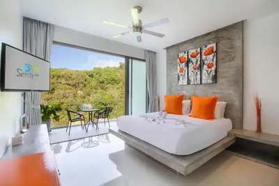 a bedroom with a bed and a large window at Serenity Villa in Bang Tao Beach