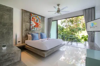 a bedroom with a bed and a large window at Serenity Villa in Bang Tao Beach