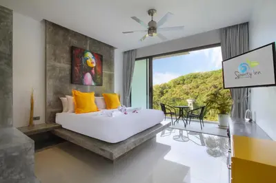 a bedroom with a bed and a large window at Serenity Villa in Bang Tao Beach