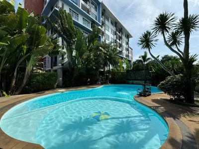 a large blue swimming pool in front of a building at Condo fodr rent The bell 50 in Ban Klang