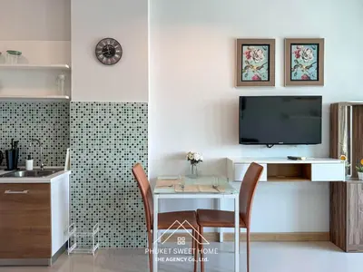 a living room with a table and a tv on a wall at Condo fodr rent The bell 50 in Ban Klang