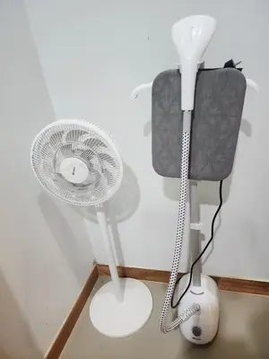 a white fan sitting next to a lamp and a chair at Damiya Peaceful House in Ban Bo Dan