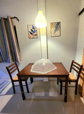 a room with a table and two chairs and a lamp at Damiya Peaceful House in Ban Bo Dan