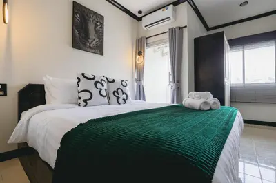 a bedroom with a large bed with a green blanket at Wink City 1 Patong Beach 4bedrooms in Patong Beach