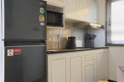a kitchen with a refrigerator and white cabinets at Wink City 1 Patong Beach 4bedrooms in Patong Beach