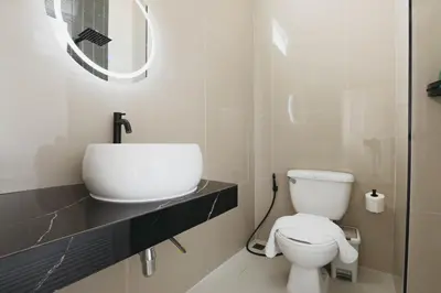 a bathroom with a white toilet and a sink at Wink City 1 Patong Beach 4bedrooms in Patong Beach