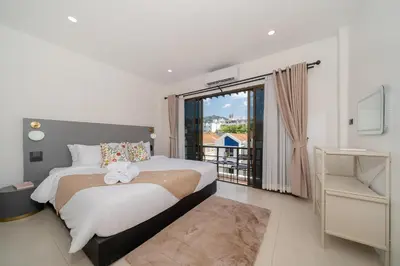 a bedroom with a large bed and a balcony at Wink Central 9 Patong Beach Phuket in Patong Beach