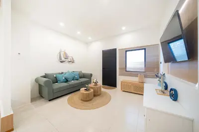 a living room with a couch and a tv at Wink Central 9 Patong Beach Phuket in Patong Beach