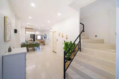 a white hallway with stairs and a dining room at Wink Central 9 Patong Beach Phuket in Patong Beach